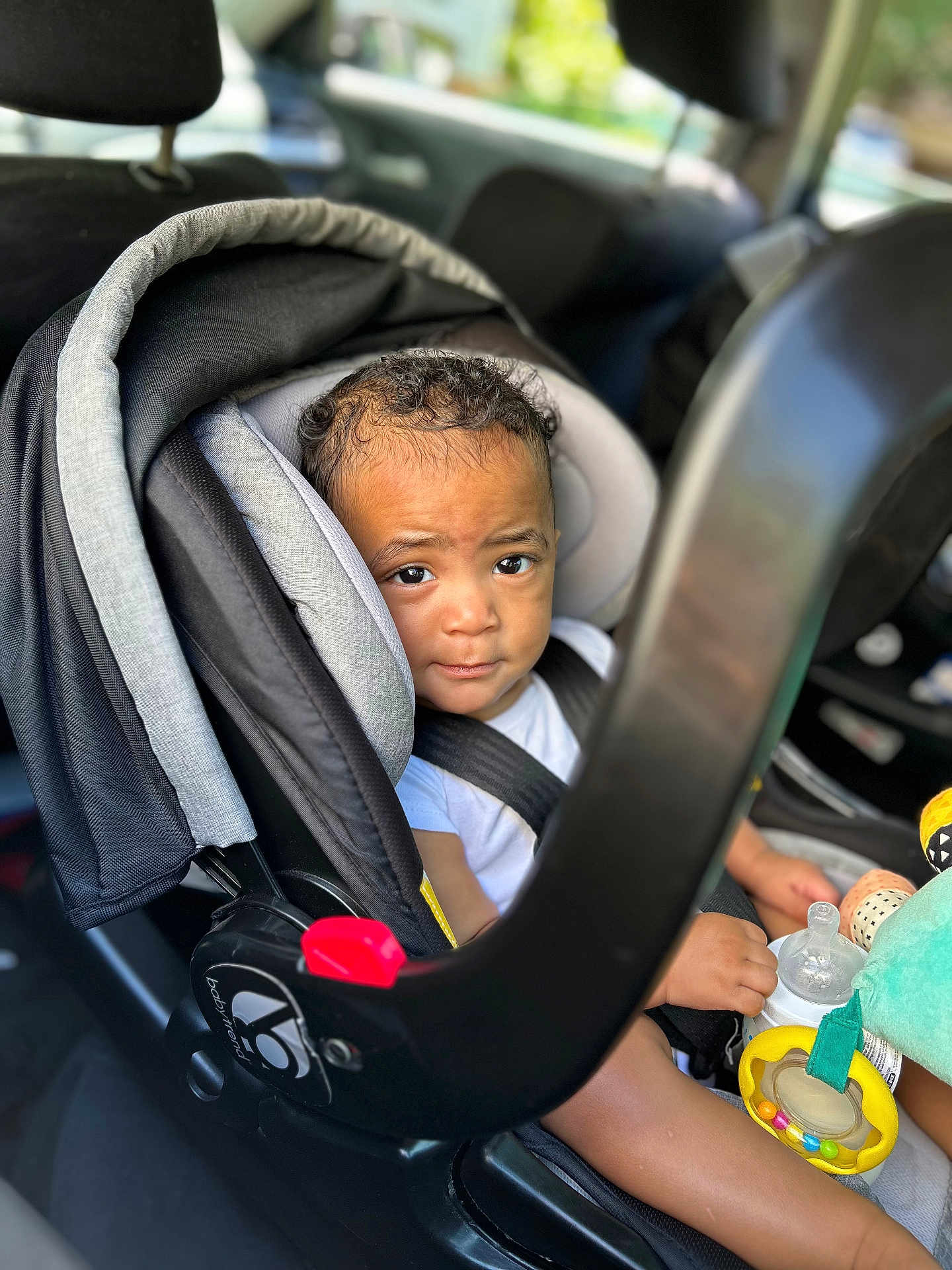 Savion joined the competition — help win amazing prizes! toddler, car_seat, child, toy, bottle, curly_hair, seatbelt, car_interior, baby, infant, window, face, expression, sitting, clothing, safety, child_protection, daylight, vehicle, cute