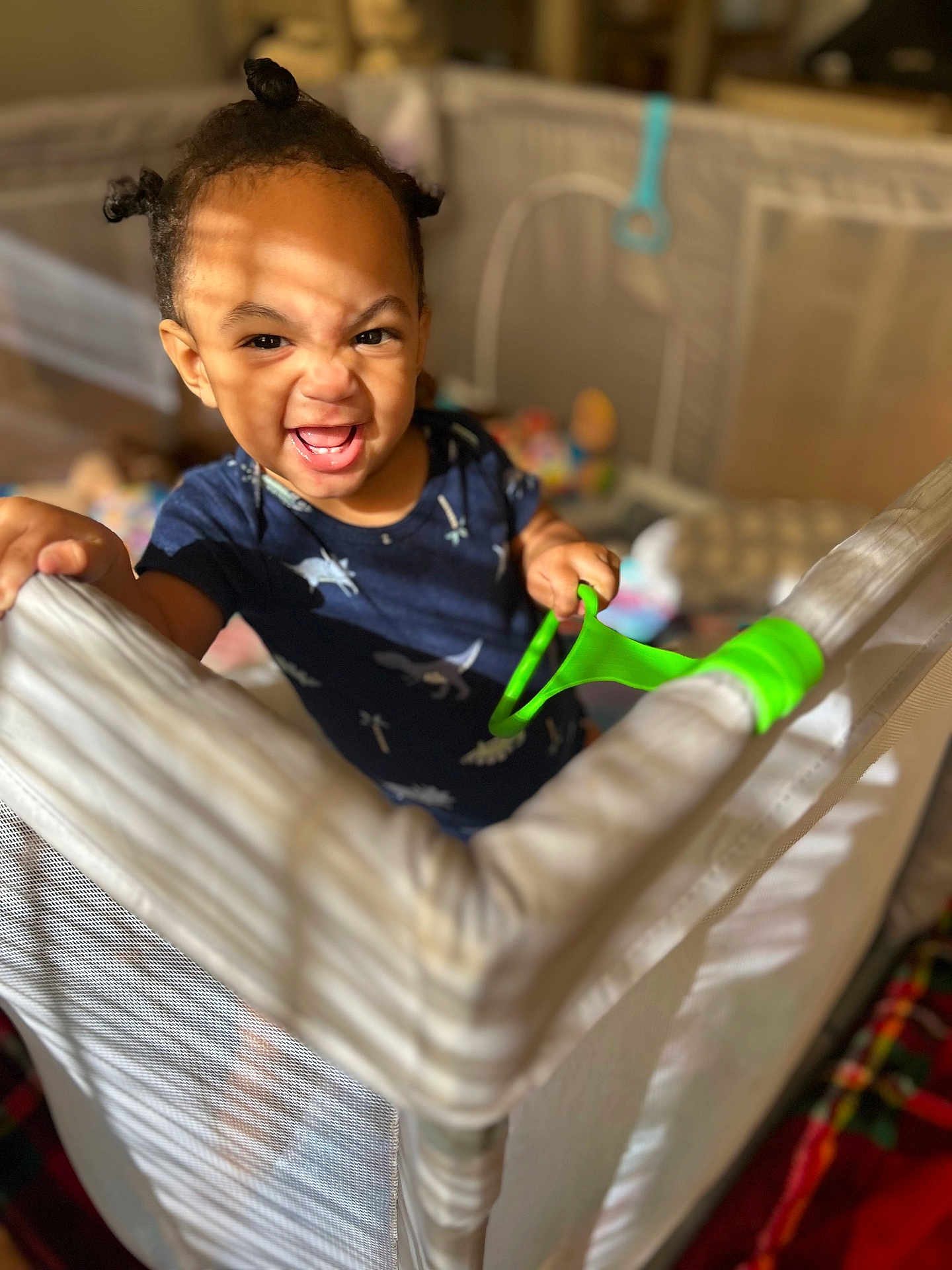 Sadon is registered to the contest to win money with this photo: toddler, child, playpen, toy, smile, happy, indoor, baby, person, clothing, hair, expression, grip, furniture, mesh, shadow, light, room, colorful, play