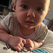 Lucille joined the competition — help win amazing prizes! baby, infant, child, face, portrait, hands, pillow, indoor, soft_lighting, curious, closeup, cute, young, person, skin, expression, resting, looking, cozy, casual