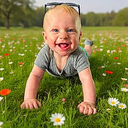 Asher joined the competition — help win amazing prizes! baby, child, grass, flowers, outdoor, smiling, crawling, greenery, sunlight, nature, sunglasses, happy, portrait, field, summer, casual_clothing, toddler, blue_eyes, daytime, playful