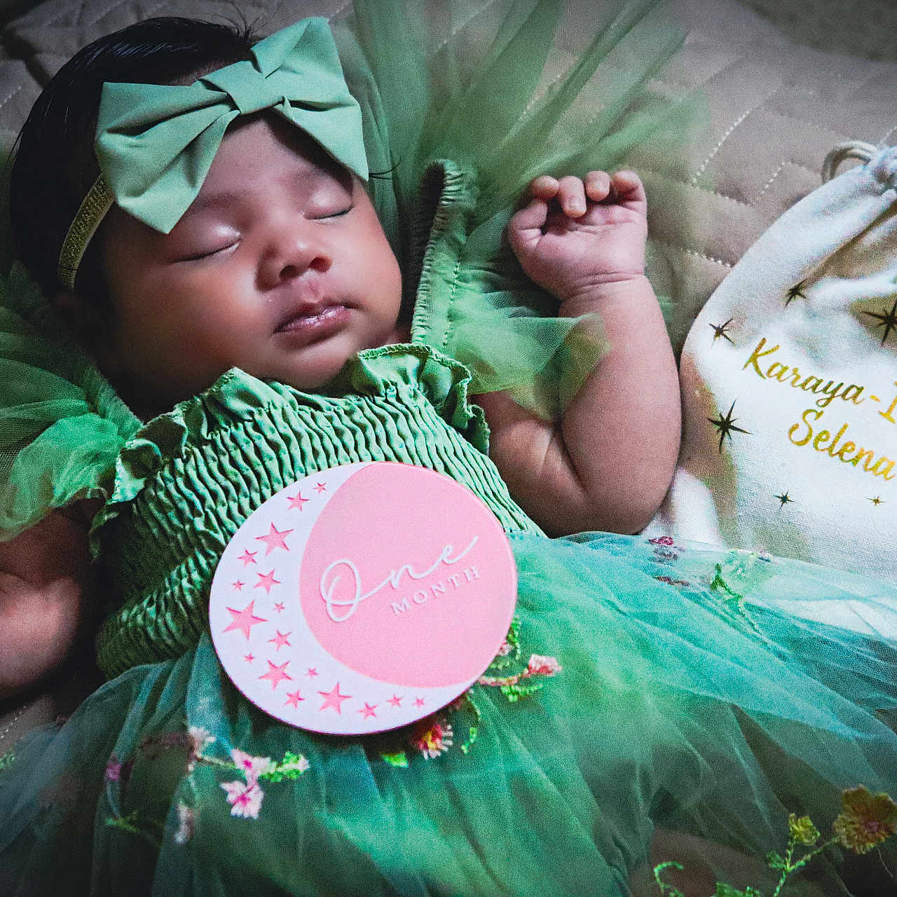 Karaya joined the competition — help win amazing prizes! baby, bow, celebration, cloth_bag, cute, fabric, green_dress, hand, headband, infant, lying_down, milestone_card, moon, one_month, peaceful, portrait, quilted_surface, sleeping, stars, tulle