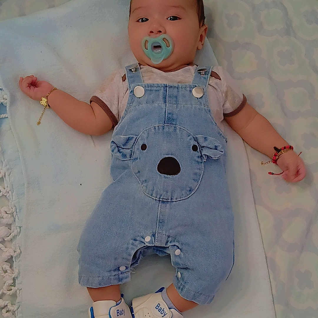 𝐌𝐚𝐭𝐭𝐡𝐞𝐰 is registered to the contest to win money with this photo: accessory, baby, blanket, blue, bracelet, child, clothing, comfort, cute, denim_overalls, footwear, indoor, infant, lying_down, pacifier, person, shoes, sleepwear, soft, white