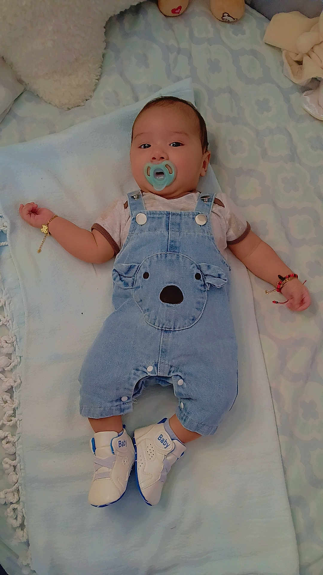 𝐌𝐚𝐭𝐭𝐡𝐞𝐰 is registered to the contest to win money with this photo: baby, pacifier, denim_overalls, shoes, bracelet, blanket, infant, cute, child, lying_down, blue, white, clothing, comfort, person, footwear, accessory, indoor, sleepwear, soft