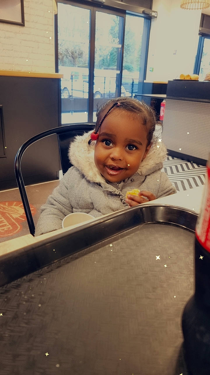 Daryanna a rejoint le concours — aidez-le/la à gagner de superbes lots ! auto_part, automotive_design, automotive_exterior, chair, child, eye, face, facial_expression, flooring, fun, happy, joy, leisure, motor_vehicle, person, room, sitting, skin, smile, table