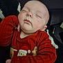 baby, sleeping, red_sweater, holiday_clothing, santa_claus, reindeer, gingerbread_man, blanket, cozy, peaceful, infant, cute, portrait, child, resting, indoors, soft_lighting, closeup, comfort, warm