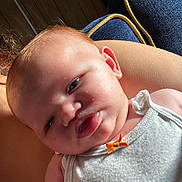 Amelia joined the competition — help win amazing prizes! baby, infant, face, skin, white_clothing, orange_bow, couch, blue_fabric, yellow_piping, arm, light, natural_light, closeup, person, expression, resting, indoors, soft_skin, head, young_child