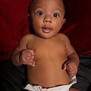 Tyrone joined the competition — help win amazing prizes! baby, infant, diaper, skin, face, eyes, hands, expression, curious, lying_down, child, cute, adorable, newborn, portrait, indoors, soft_background, red, black, small_fingers