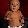 baby, infant, diaper, bare_chest, wide_eyes, curious_expression, lying_down, red_blanket, black_blanket, skin, cute, child, portrait, indoors, one_person, young_child, human, face, hands, looking_up