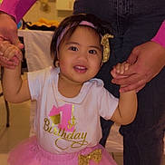 Heipoe a rejoint le concours — aidez-le/la à gagner de superbes lots ! toddler, birthday, celebration, pink_tutu, white_shirt, golden_lettering, headband, smiling, holding_hands, adult, indoor, balloons, party, child, person, happy, festive, clothing, jeans, sweater