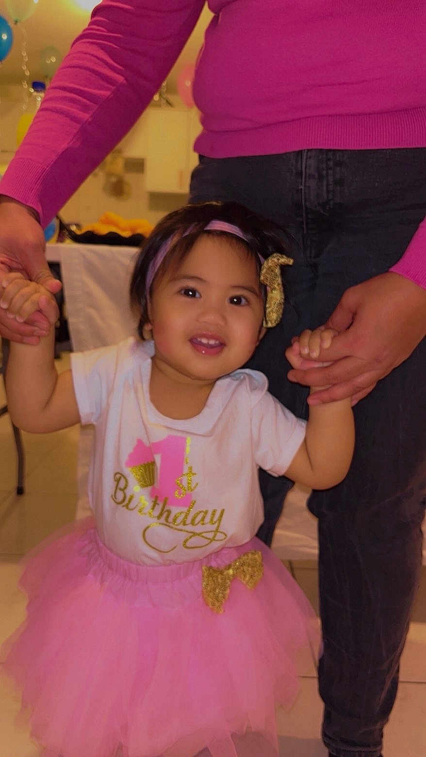 Heipoe a rejoint le concours — aidez-le/la à gagner de superbes lots ! toddler, birthday, celebration, pink_tutu, white_shirt, golden_lettering, headband, smiling, holding_hands, adult, indoor, balloons, party, child, person, happy, festive, clothing, jeans, sweater