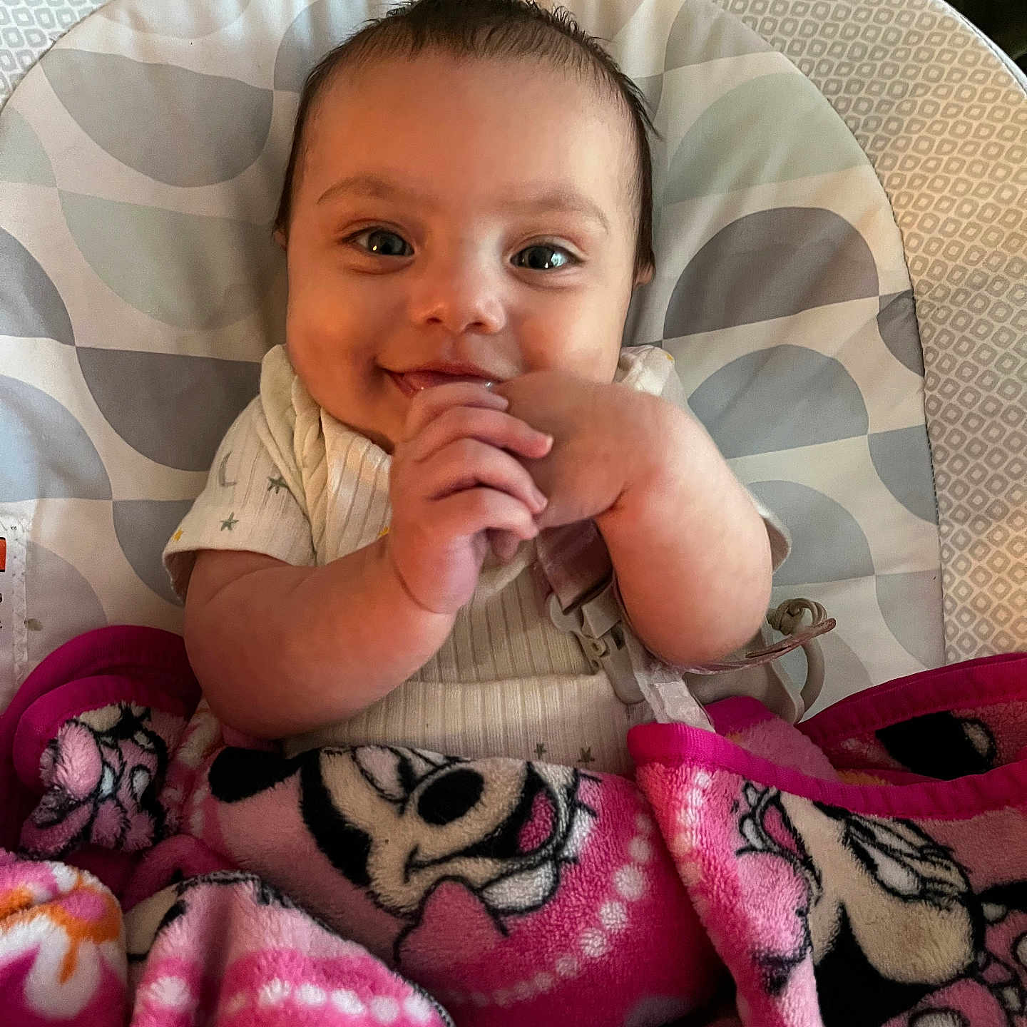 Genesis is registered to the contest to win money with this photo: baby, baby_boy, blanket, child, clothing, cozy, cute, expression, face, hands, happy, indoor, infant, minnie_mouse, pattern, person, pink, portrait, seat, smiling