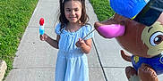 Kennedi joined the competition — help win amazing prizes! child, girl, popsicle, balloon, sidewalk, street, grass, summer, daylight, casual_clothing, smile, pigtails, footwear, outdoor, residential_area, balloon_character, happy, playful, neighborhood, concrete