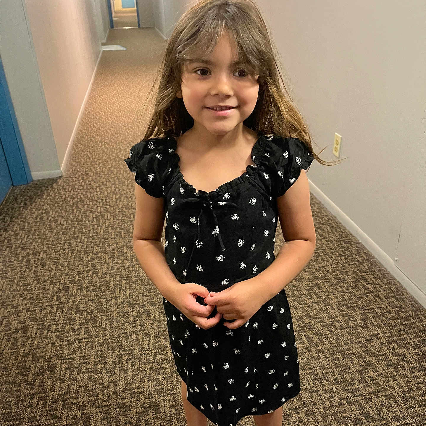 Kennedi joined the competition — help win amazing prizes! black_dress, carpet, child, clothing, door, floor, girl, hair, hallway, happy, indoor, lighting, long_hallway, person, portrait, smiling, standing, wall, white_sandals, young
