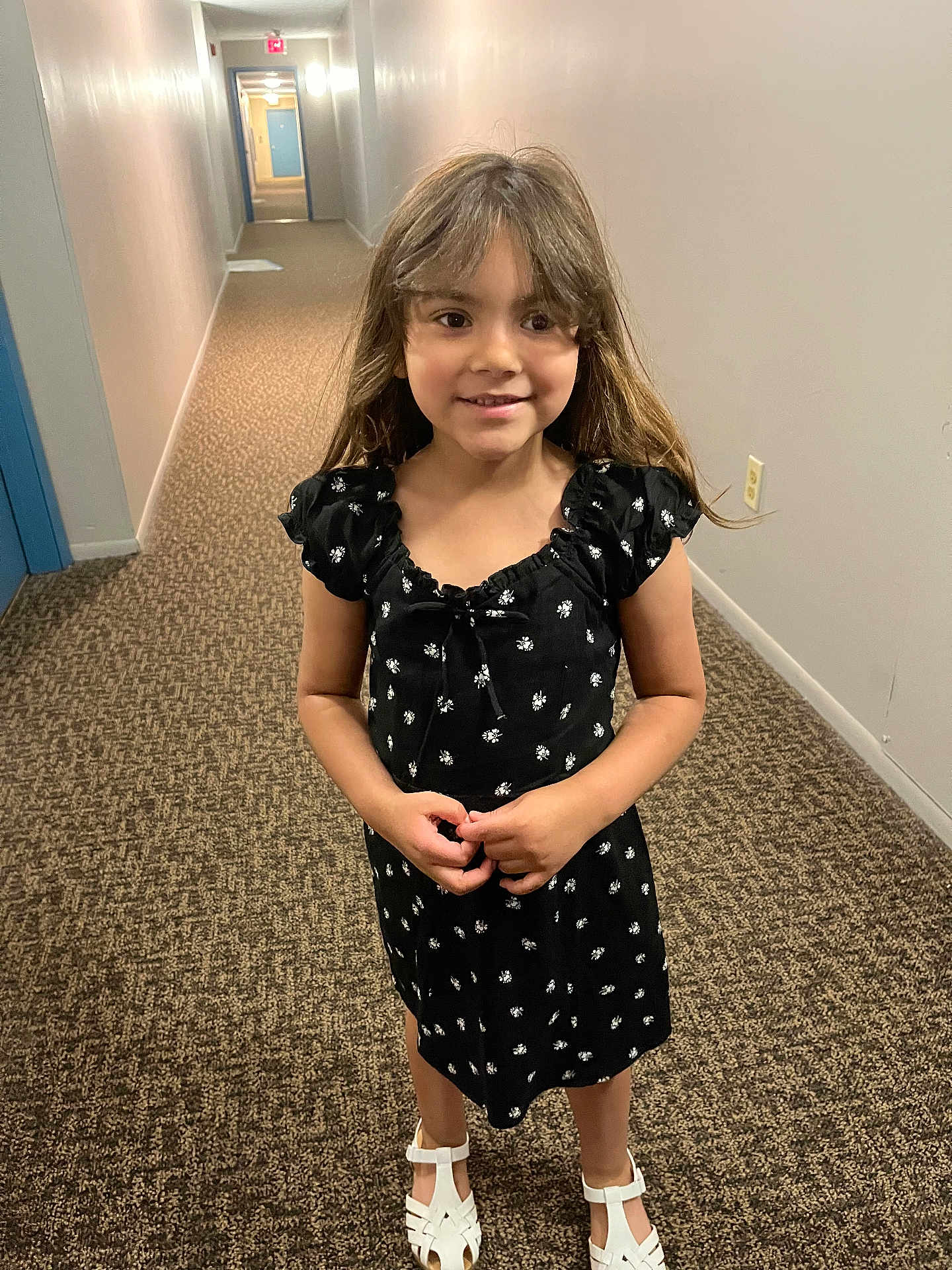 Kennedi joined the competition — help win amazing prizes! child, girl, smiling, black_dress, white_sandals, hallway, carpet, long_hallway, door, lighting, person, standing, indoor, young, happy, clothing, portrait, hair, wall, floor