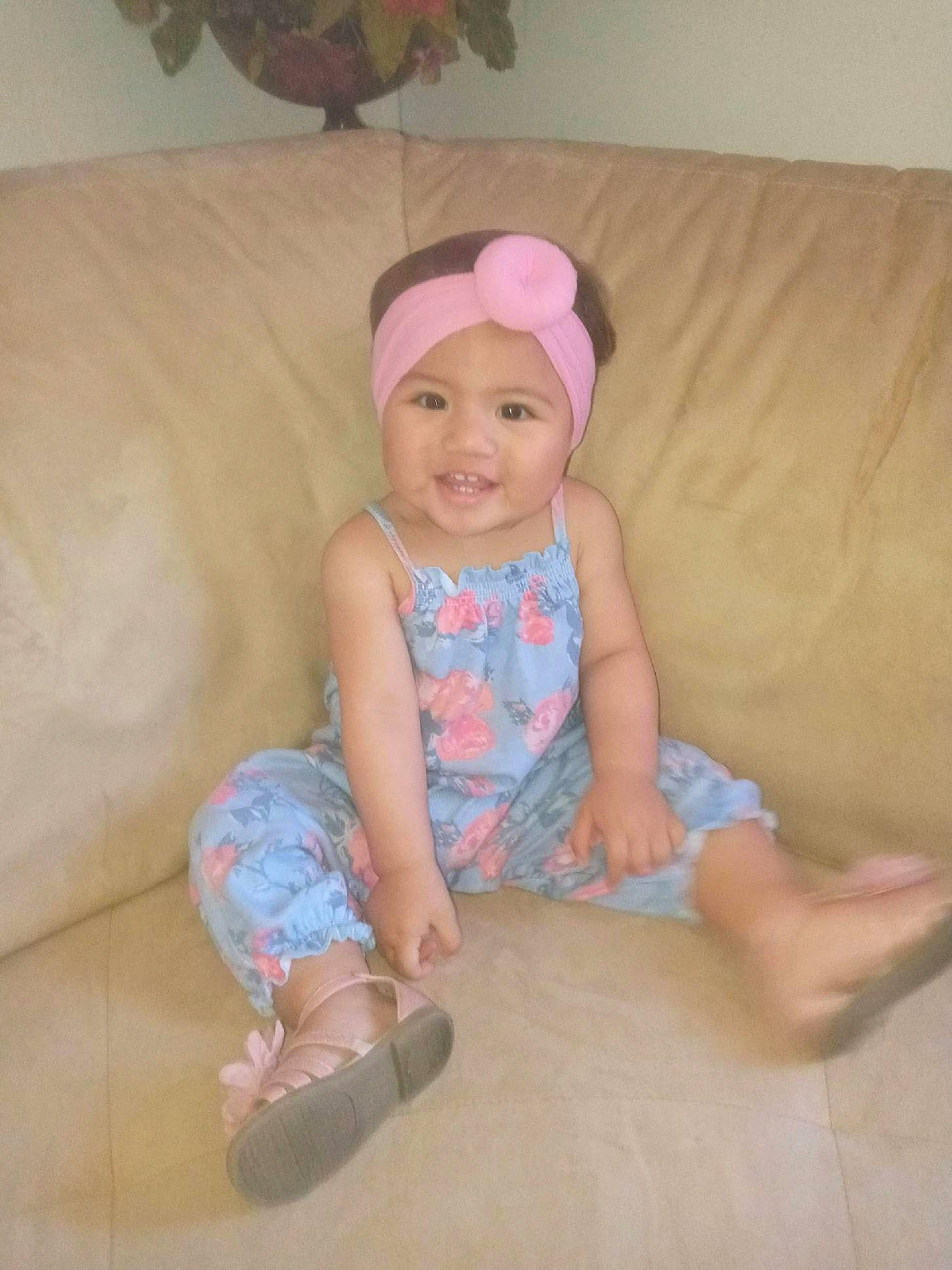 Jade is registered to the contest to win money with this photo: baby, baby_toddler_clothing, child, comfort, couch, floor, flooring, fun, headwear, human_leg, joy, person, pink, shorts, sitting, skin, sleeve, smile, sock, t_shirt