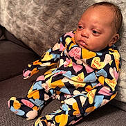 Gianna Jean Spivey is registered to the contest to win money with this photo: baby, infant, pajamas, colorful_clothing, heart_pattern, couch, blanket, furniture, indoors, child, person, cute, soft_texture, relaxed, seated, portrait, young, warm, comfort, home
