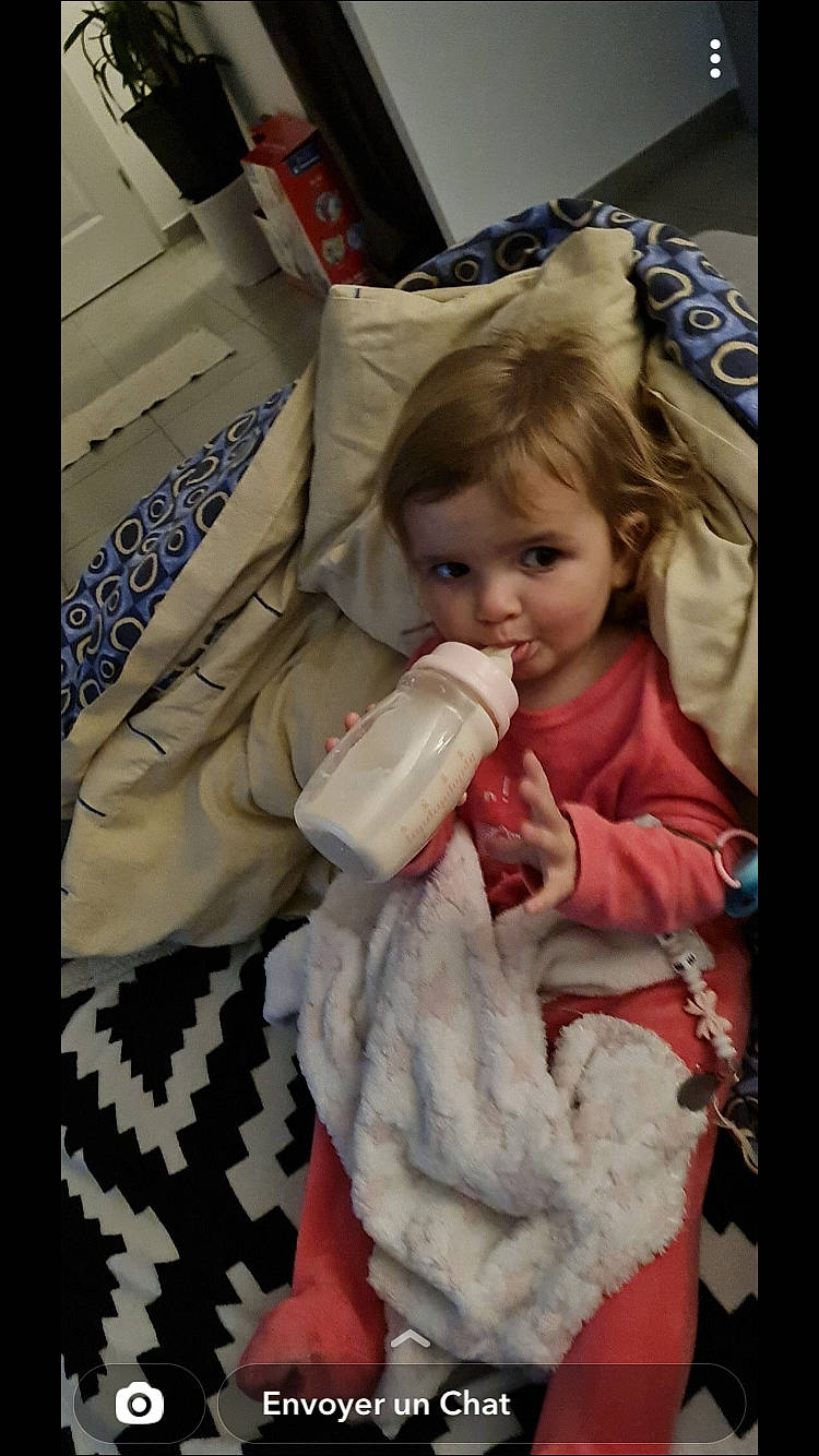 Enéa participe au concours pour gagner de l'argent avec cette photo : baby, baby_products, baby_toddler_clothing, cheek, child, christmas, christmas_eve, comfort, drinkware, event, fun, fur, glove, person, plastic_bottle, room, sitting, skin, smile, toddler