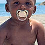 baby, pacifier, beach, sand, ocean, water, child, portrait, sunlight, bare_chest, diaper, outdoor, summer, sea, young_child, infant, skin, people, nature, vacation