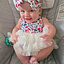 baby, child, smiling, bow, headband, dress, tulle_skirt, sitting, chair, cushion, cute, happy, indoor, person, infant, skin, foot, hand, face, dimples