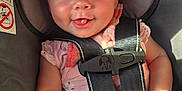 Juni joined the competition — help win amazing prizes! baby, blue_eyes, car_seat, child, closeup, cute, face, hand, happy, indoor, infant, person, pink_clothing, portrait, safety_harness, seat, seatbelt, smiling, sunlight, toy
