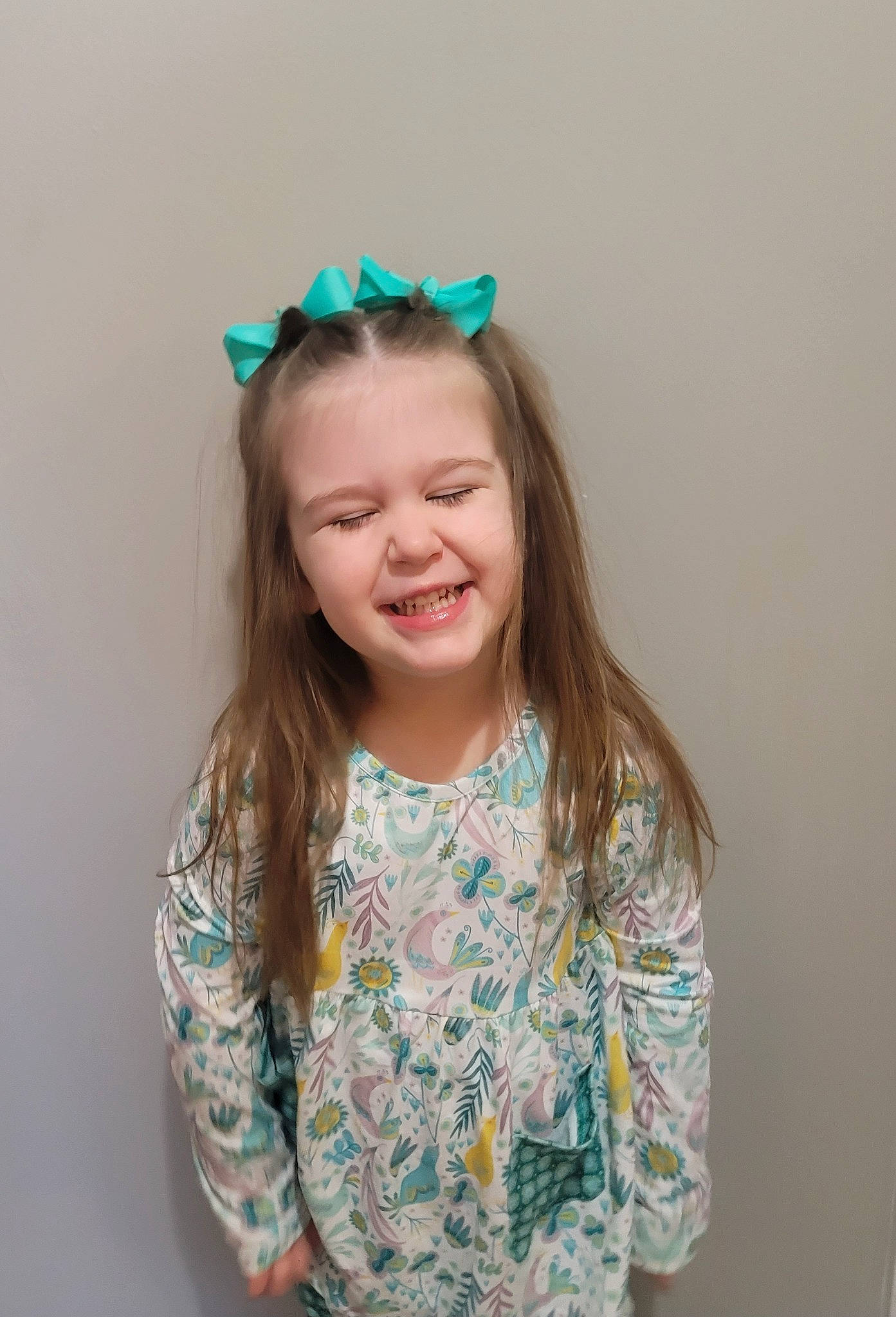 Tessa is registered to the contest to win money with this photo: aqua, arm, baby_toddler_clothing, blond, child, facial_expression, gesture, hair, hair_tie, hairstyle, happy, headpiece, joy, neck, pattern, person, pink, skin, sleeve, smile