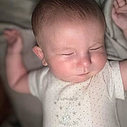Wyatt is registered to the contest to win money with this photo: baby, sleeping, infant, arm, face, onesie, polka_dots, soft_light, close_up, peaceful, skin, head, cute, child, resting, indoors, portrait, newborn, expression, relaxation