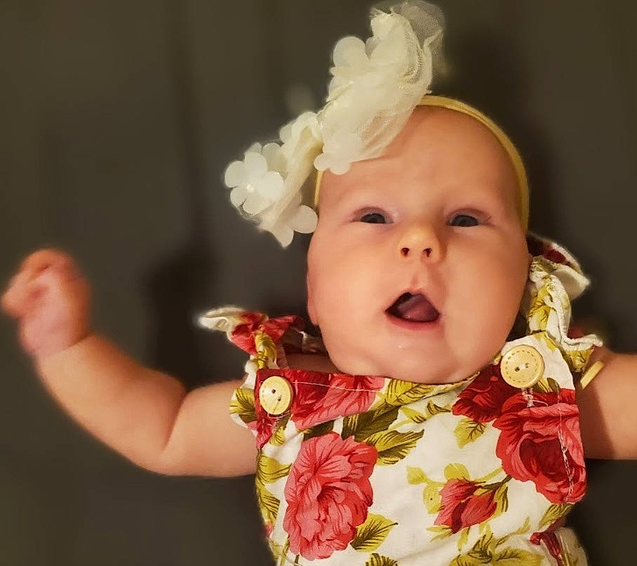 Serenity is registered to the contest to win money with this photo: baby, baby_toddler_clothing, cheek, child, costume_hat, cut_flowers, event, fashion_accessory, hair_accessory, happy, headband, headgear, headpiece, iris, peach, person, petal, pink, portrait_photography, sweetness