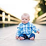 Jameson joined the competition — help win amazing prizes! baby, child, blue_plaid_shirt, jeans, barefoot, wooden_boardwalk, outdoor, portrait, sitting, curious, serious_expression, blurry_background, railings, nature, daylight, casual_clothing, cute, infant, young_child, people