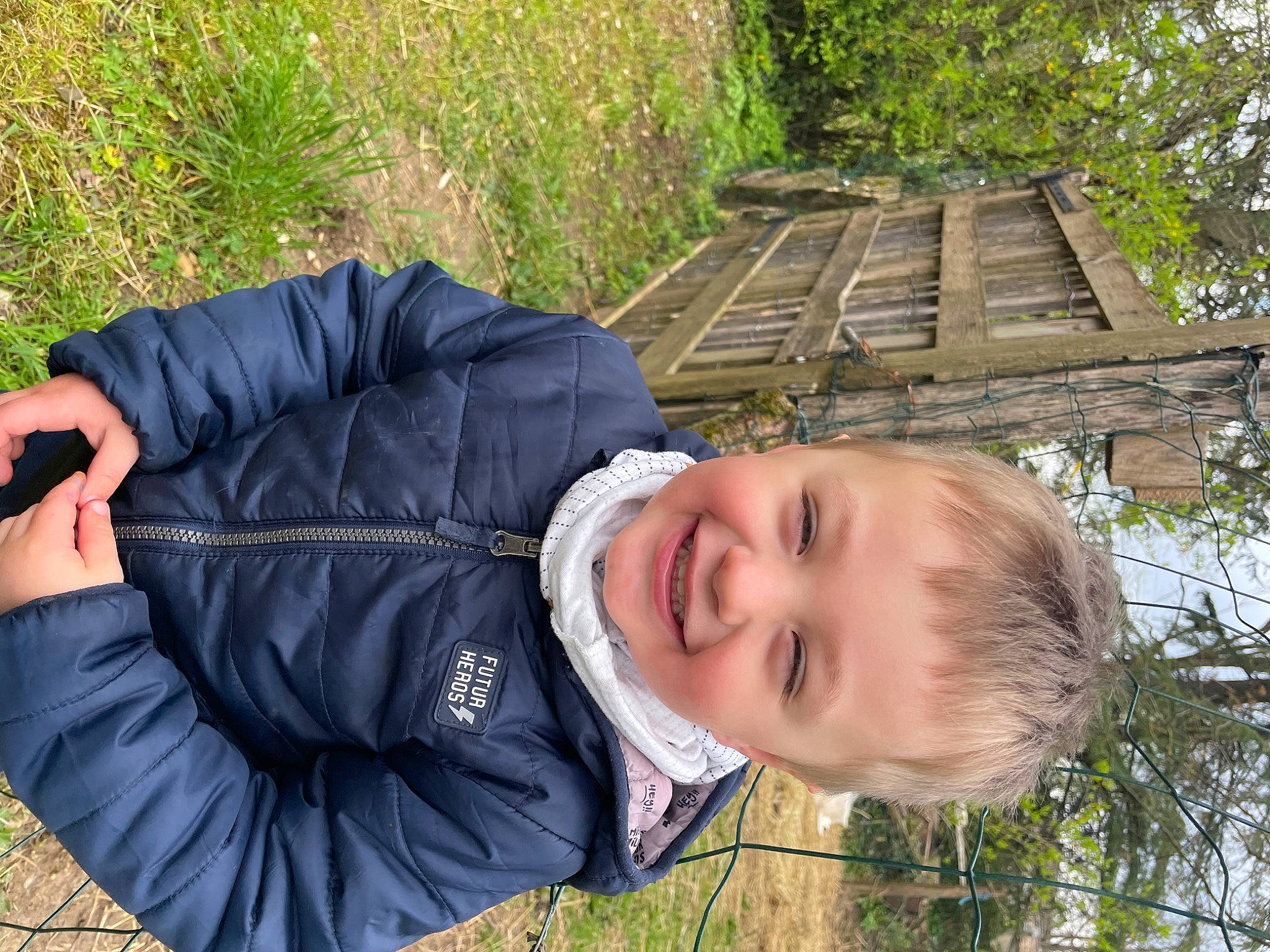 Basile participe au concours pour gagner de l'argent avec cette photo : baby, baby_toddler_clothing, child, fun, fur, grass, happy, head, jacket, joy, laugh, leaf, leisure, people_in_nature, person, plant, portrait_photography, sitting, smile, toddler