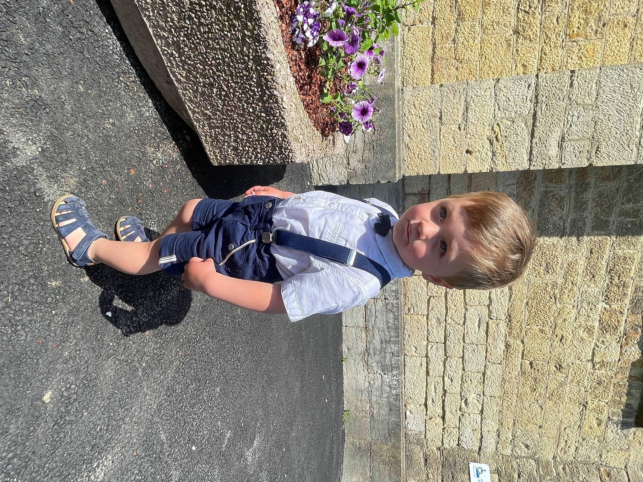 Basile participe au concours pour gagner de l'argent avec cette photo : asphalt, child, cobblestone, concrete, electric_blue, fun, grass, human_leg, leisure, pattern, pedestrian, person, plant, road_surface, shadow, sidewalk, sitting, street, toddler, vacation
