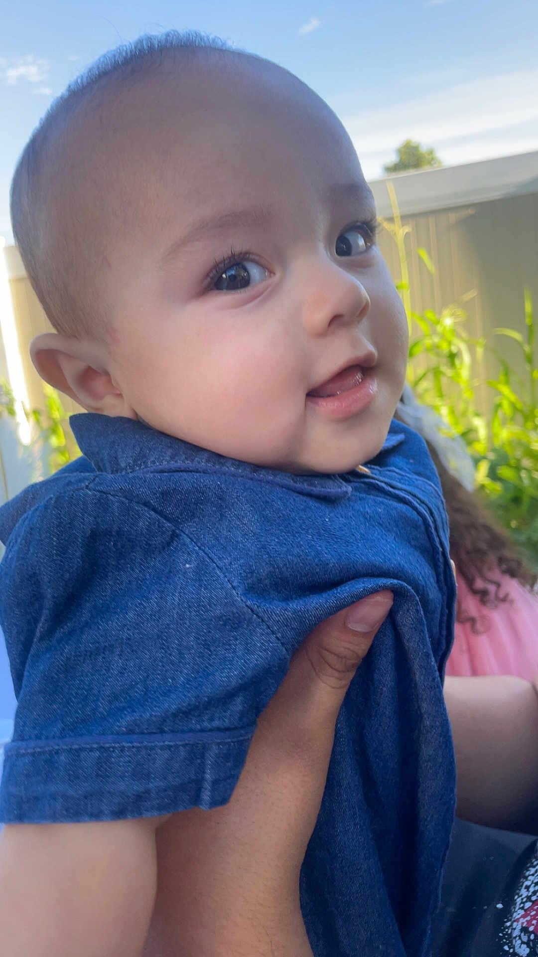 Noah joined the competition — help win amazing prizes! baby, child, face, smile, denim, clothing, hand, outdoor, nature, fence, skin, person, portrait, happy, young, curious, holding, blue, daylight, background