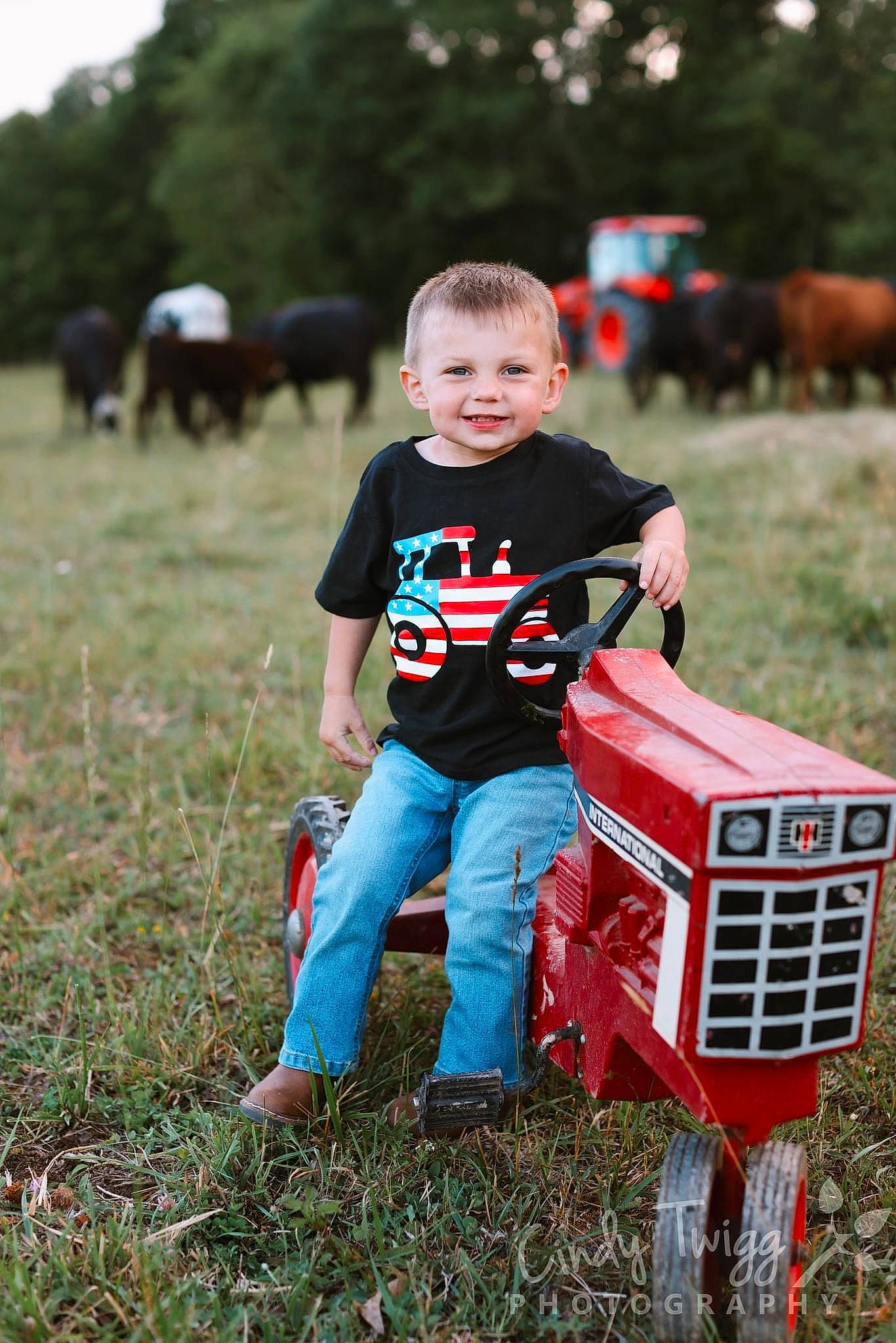 Boone is registered to the contest to win money with this photo: fun, grass, grassland, happy, human_settlement, jeans, joy, landscape, lawn, leisure, motor_vehicle, people, people_in_nature, person, plant, recreation, rural_area, sitting, summer, t_shirt
