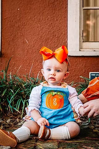 Everlea is registered to the contest to win money with this photo: baby, baby_toddler_clothing, brown_hair, cheek, child, costume, doll, eye, fawn, figurine, grass, headgear, orange, peach, person, portrait_photography, sitting, toddler, toy, window