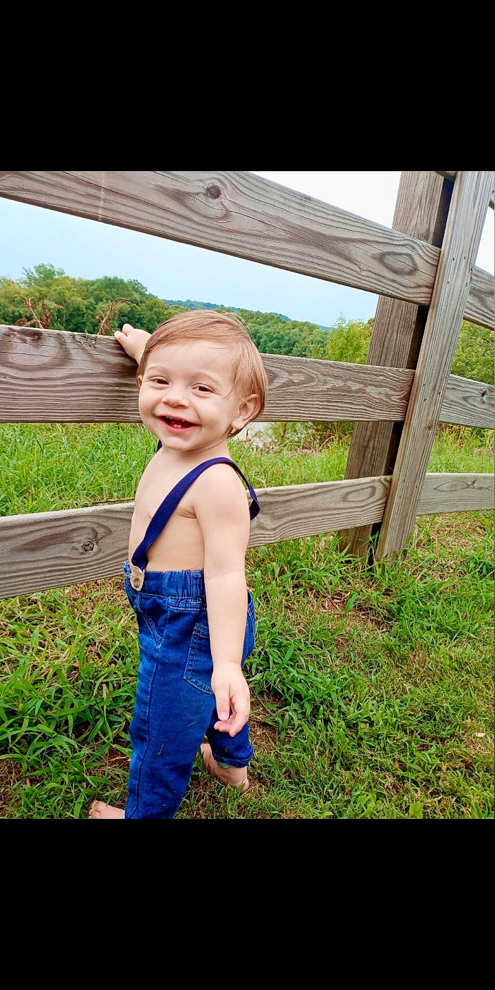 Henry is registered to the contest to win money with this photo: baby_toddler_clothing, blond, child, electric_blue, flash_photography, fun, gesture, grass, grassland, hair, happy, joy, leaf, leisure, people_in_nature, person, plant, shoulder, sky, smile