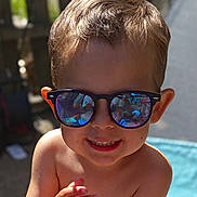Kaïs a rejoint le concours — aidez-le/la à gagner de superbes lots ! child, boy, sunglasses, smile, portrait, outdoor, sunlight, reflection, face, hair, skin, hand, summer, backyard, happy, casual, closeup, toddler, playful, barechest