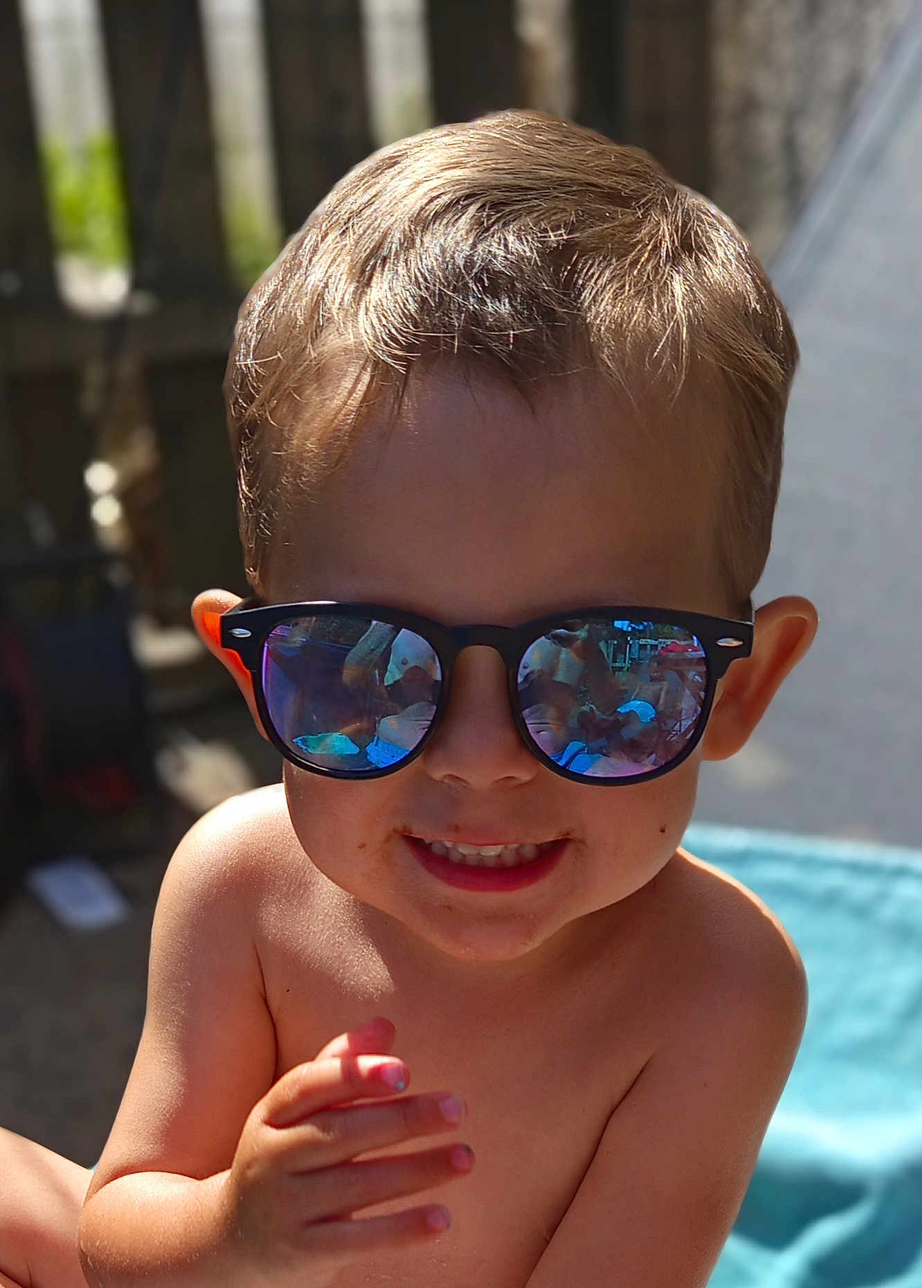 Kaïs a rejoint le concours — aidez-le/la à gagner de superbes lots ! child, boy, sunglasses, smile, portrait, outdoor, sunlight, reflection, face, hair, skin, hand, summer, backyard, happy, casual, closeup, toddler, playful, barechest