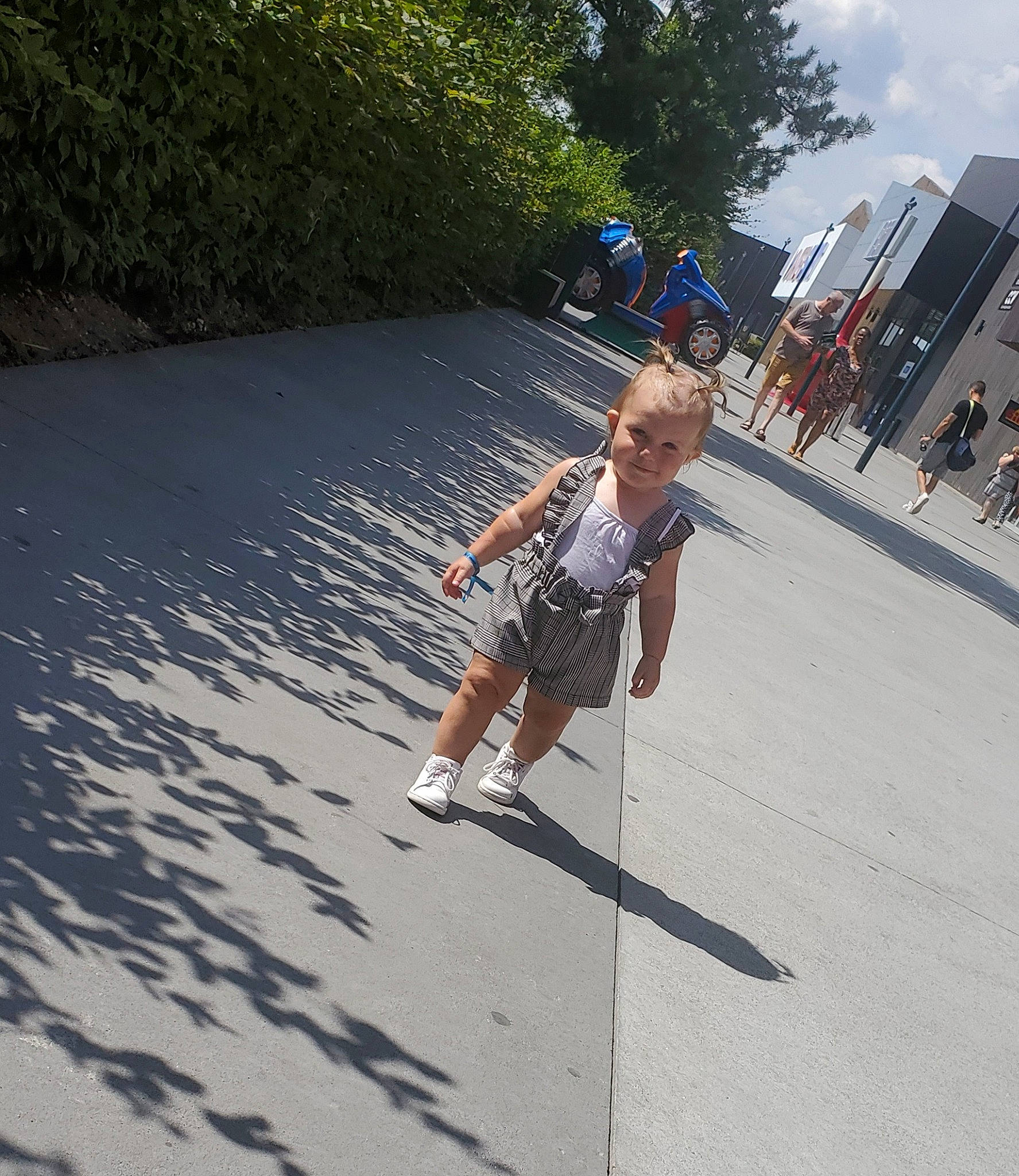 Nelya a rejoint le concours — aidez-le/la à gagner de superbes lots ! asphalt, child, city, electric_blue, fun, grass, joy, leisure, pedestrian, person, plant, recreation, road, road_surface, shadow, shorts, sidewalk, sky, street, toddler