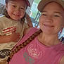 Osmar is registered to the contest to win money with this photo: child, woman, smile, selfie, cap, braid, indoor, window, blinds, casual_clothing, happy, family, portrait, person, young_child, adult, living_room, natural_light, hat, cute