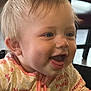 apparel, baby, child, closeup, cute, expression, face, happy, head, human, indoor, infant, joyful, person, pink_clothing, portrait, sitting, smiling, tongue_out, young_child