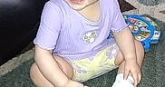 Savannah joined the competition — help win amazing prizes! baby, carpet, child, cute, floor, furniture, hand, headband, indoor, living_room, playtime, portrait, purple_shirt, rug, shoe, sitting, smiling, teeth, toddler, toy