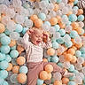 Victoria participe au concours pour gagner de l'argent avec cette photo : child, toddler, ball_pit, colorful_balls, pastel_colors, orange_balls, blue_balls, white_balls, happy, playing, indoor, casual_clothing, smiling, joy, fun, cute, young_child, socks, blond_hair, relaxing