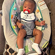 Javonte joined the competition — help win amazing prizes! baby, infant, pacifier, onesie, bib, baby_rocker, striped_clothing, socks, indoor, couch, patterned_fabric, cute, child, person, relaxing, toy, bright_starts, face, hands, legs