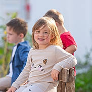 Elena participe au concours pour gagner de l'argent avec cette photo : child, smiling, bench, outdoor, sunlight, casual_clothing, long_hair, cute, playful, kids, friends, wood, nature, daylight, happy, girl, pants, sweater, heart_pattern, relaxed