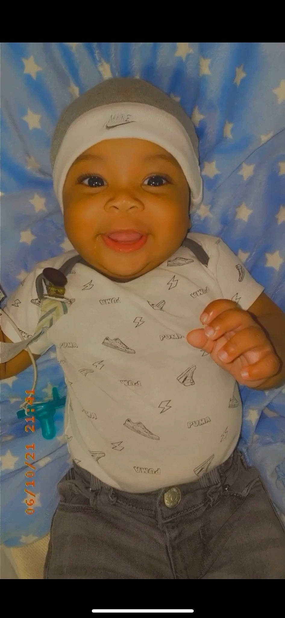 Mack is registered to the contest to win money with this photo: baby, cap, cheek, eye, eyebrow, face, facial_expression, forehead, gesture, happy, head, headwear, mouth, nose, organ, person, skin, sleeve, smile, textile