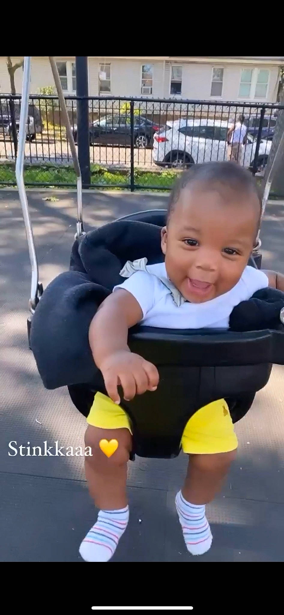 Mack is registered to the contest to win money with this photo: baby, baby_products, baby_toddler_clothing, child, city, fence, fun, grass, happy, head, leisure, person, plant, play, recreation, sitting, skin, smile, t_shirt, toddler