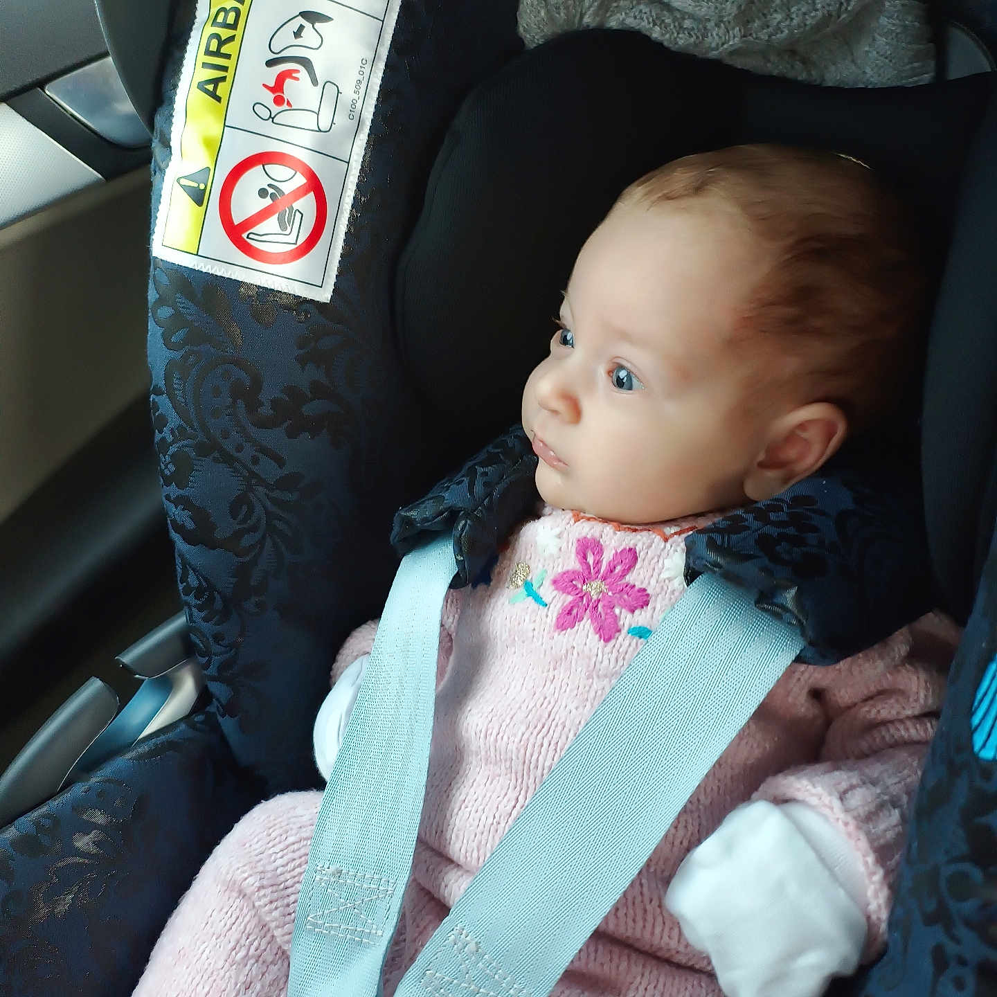 Ruxandra is registered to the contest to win money with this photo: baby, blue_eyes, car_interior, car_seat, child, child_safety, cute, infant, knitted, looking, mittens, pink_clothing, portrait, safety, seat, seatbelt, side_view, soft_lighting, window, young_child