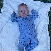 Arlo joined the competition — help win amazing prizes! baby, blue_onesie, blanket, grass, smiling, infant, outdoors, footed_pajamas, happy, cute, child, lying_down, patterned_clothing, soft_blanket, nature, young_child, face, portrait, one_person, daylight