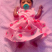 Yeilani is registered to the contest to win money with this photo: baby, infant, pink_dress, strawberry_pattern, pacifier, blanket, heart, love, cute, lying_down, soft_texture, child, adorable, clothing, portrait, indoors, person, sleepwear, baby_girl, comfortable