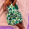 Yeilani joined the competition — help win amazing prizes! baby, infant, child, dress, shamrock, green, blanket, pink, purple, floor, pacifier, hand, lying_down, soft_texture, cute, indoors, skin, person, foot, earring