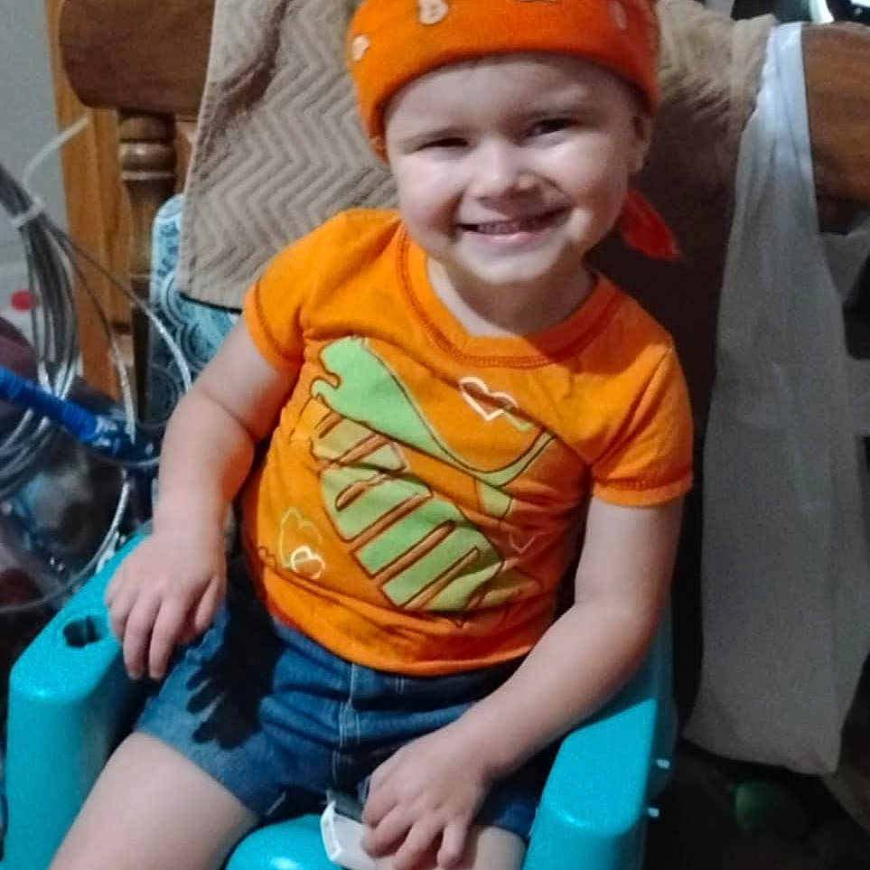 Skylar is registered to the contest to win money with this photo: accessories, baby, bathroom, clothing, cushion, face, furniture, head, homedecor, indoors, person, photography, plant, portrait, pottedplant, room, shorts, sitting, t_shirt, toilet